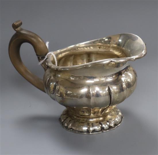 A demi fluted white metal milk jug.